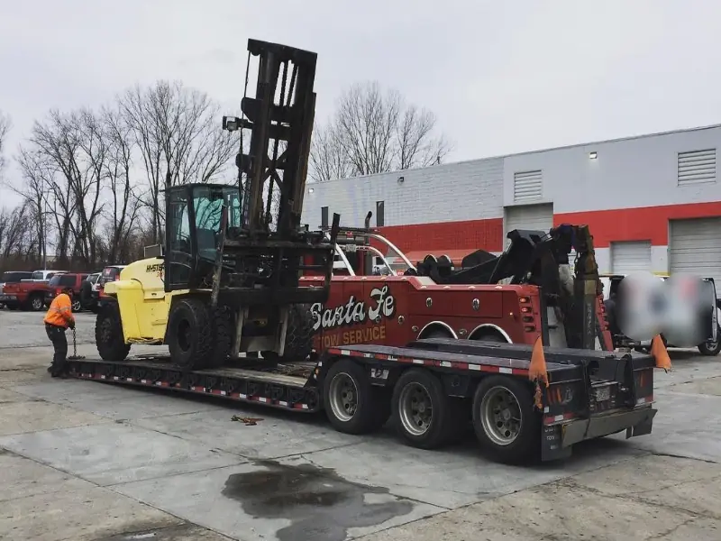 Heavy equipment tie-down chains securing excavator on lowboy trailer
